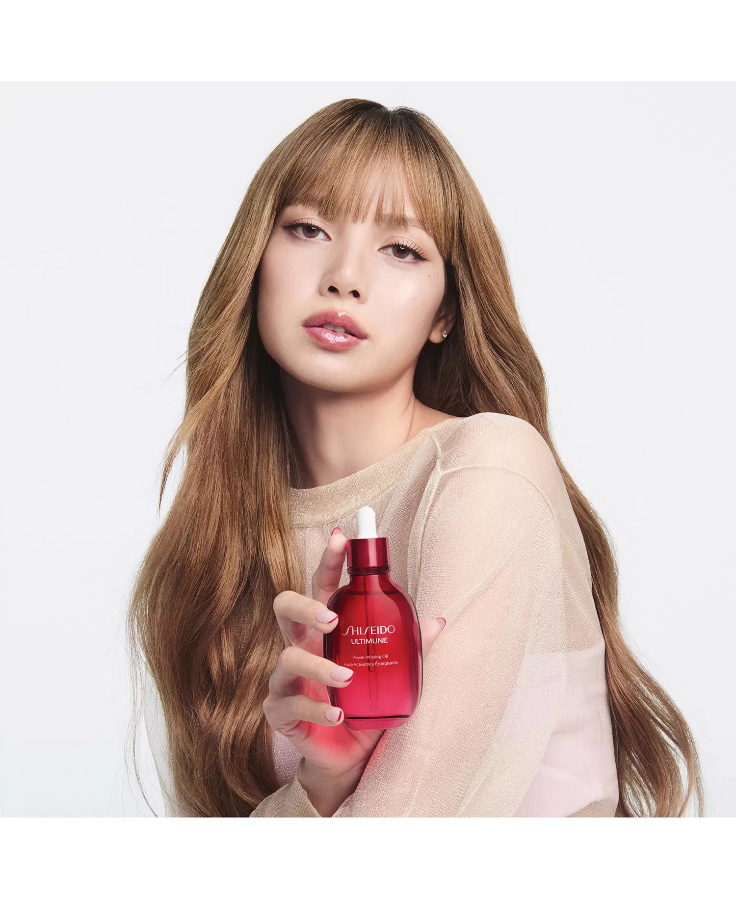 Lisa holding a red Ultimune Power Infusing Oil bottle